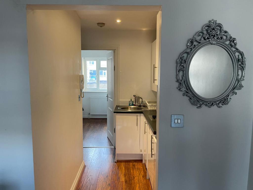 a kitchen with a mirror on the wall next to a door at Bethnal Cove in London