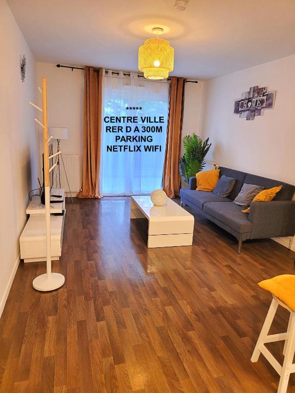 sala de estar con sofá azul y suelo de madera en III Appart 2 Pièces, Neuf 200 m de Gare Parking Netflix Evry Courcouronnes, en Courcouronnes