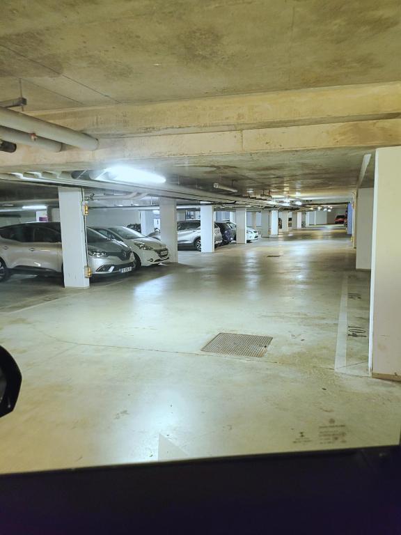 un estacionamiento vacío con coches aparcados en él en III Appart 2 Pièces, Neuf 200 m de Gare Parking Netflix Evry Courcouronnes, en Courcouronnes