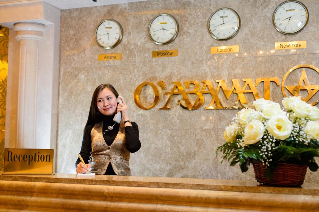 Uma mulher ao balcão a falar ao telemóvel em O Azamat em Astana
