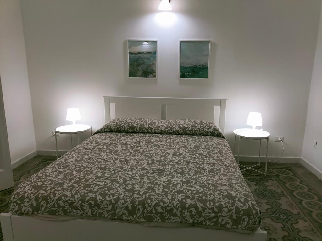 a bedroom with a bed with two lamps on the wall at Appartamento Hygge incantevole in Reggio di Calabria