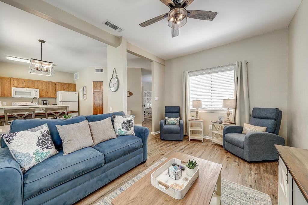 a living room with a blue couch and a table at Leeward Isles 207 in Padre Island