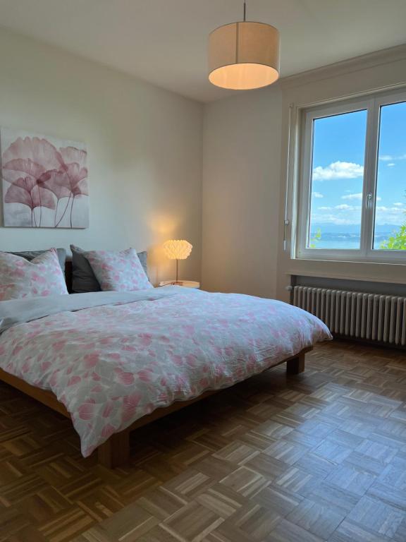 a bedroom with a large bed and a large window at Alpes Rez in Neuchâtel