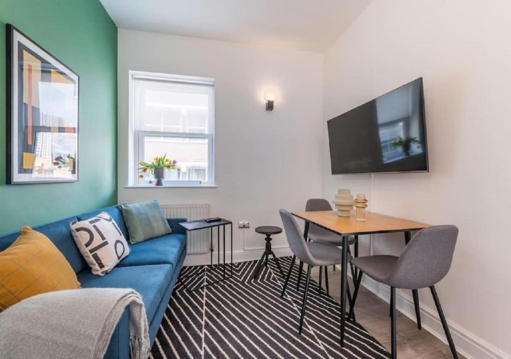- un salon avec un canapé bleu et une table dans l'établissement 2 Bedroom - Tower Bridge - London City by Prime London Stays M-11, à Londres
