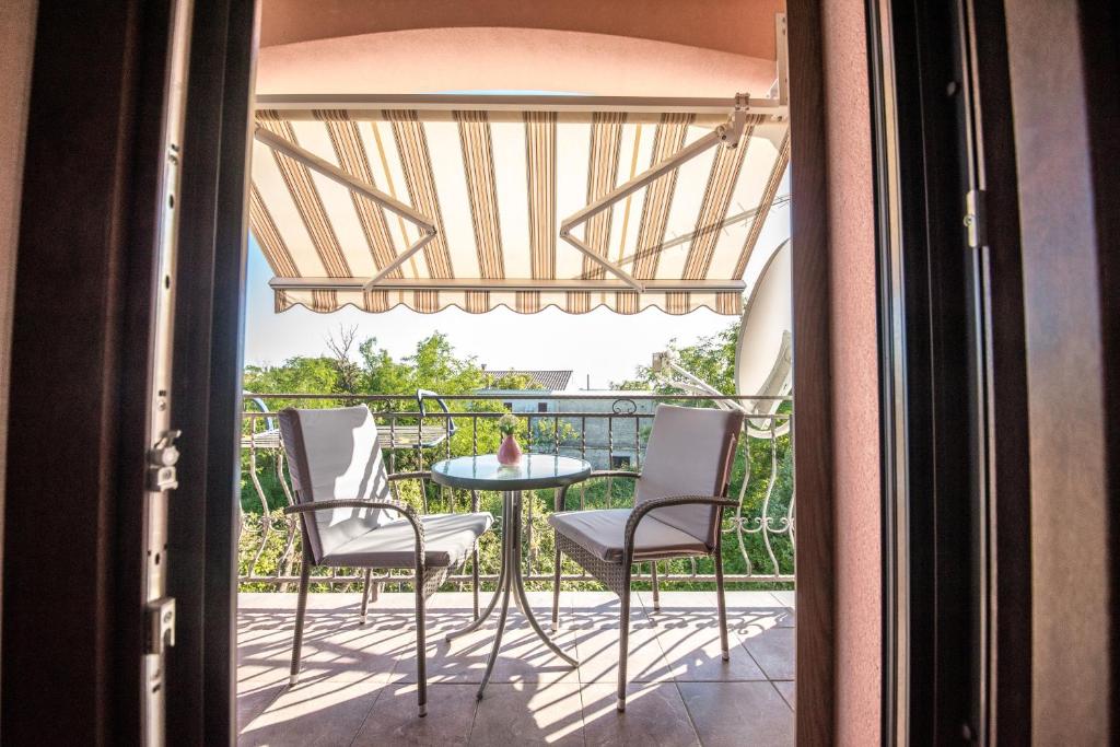 patio z krzesłami i stołem na balkonie w obiekcie Apartments and rooms by the sea Vrsi - Mulo, Zadar - 5848 w mieście Vrsi
