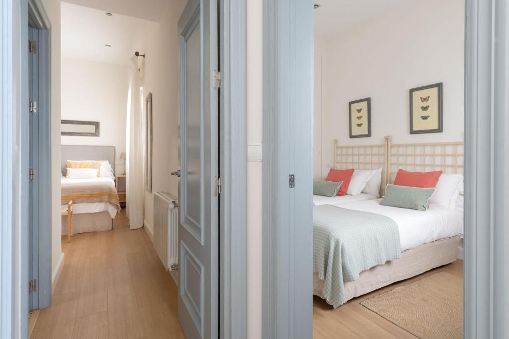 um quarto com uma cama com almofadas vermelhas e verdes em Plaza Nueva 2 Bedrooms & 2 Bathrooms em Sevilha