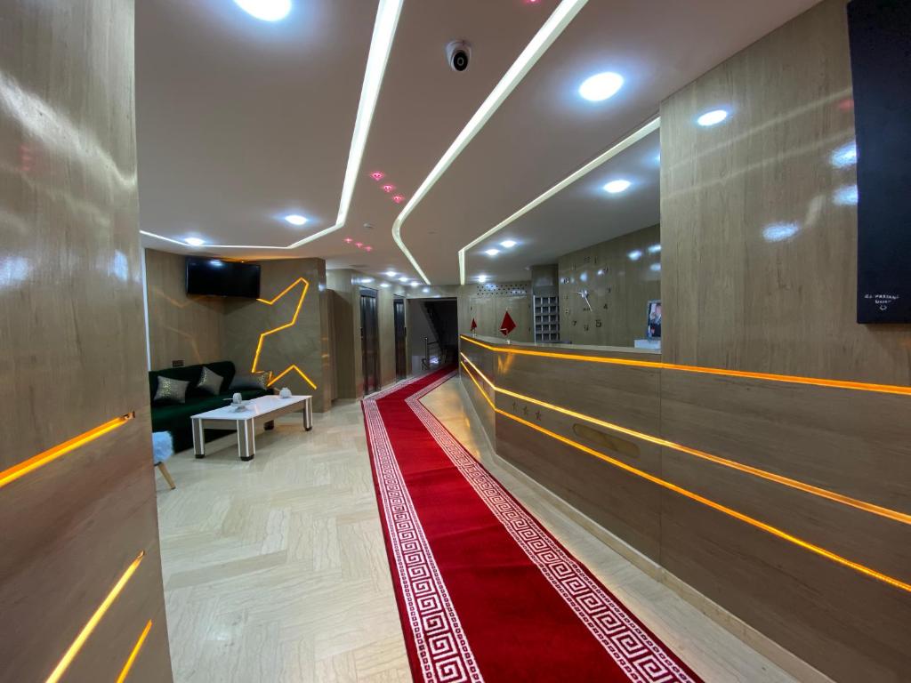 a hallway with a red carpet and a bowling alley at Hôtel Chark in Guercif