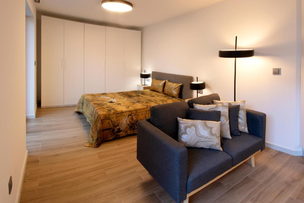a bedroom with a bed and a couch at RIACENTRUM - Smart Residence in Aveiro