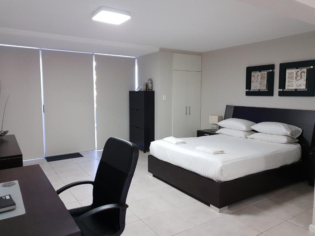 een slaapkamer met een bed, een bureau en een stoel bij Studio 4 - ground floor Fremantle apartment in Fremantle