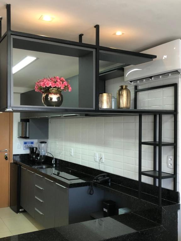 a kitchen with a sink and a vase of flowers at » MODERNO E ACONCHEGANTE FLAT COM VARANDA « in João Pessoa