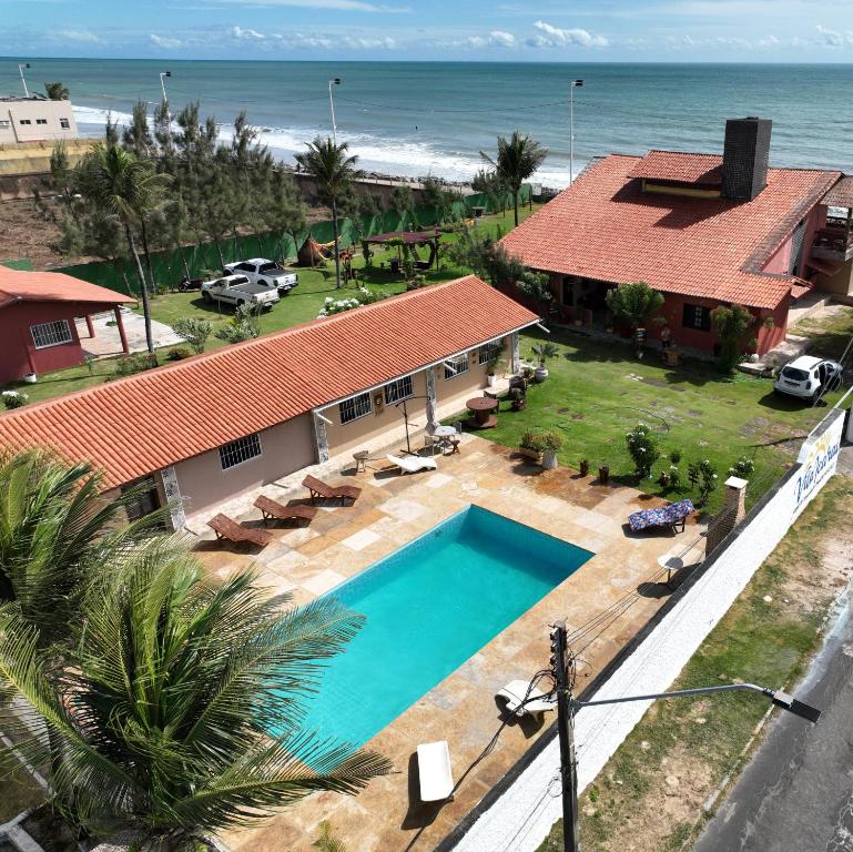 an aerial view of a house with a swimming pool and the ocean at Vila icarai in Caucaia