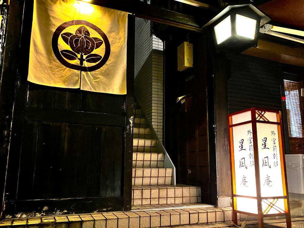 um sinal na lateral de um edifício com uma bandeira em 外宮前別邸　星凪庵 em Ise