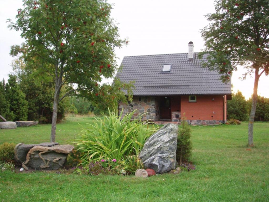 a house in a yard with a rock in front of it at Pruuli Holiday Farm in Sõru