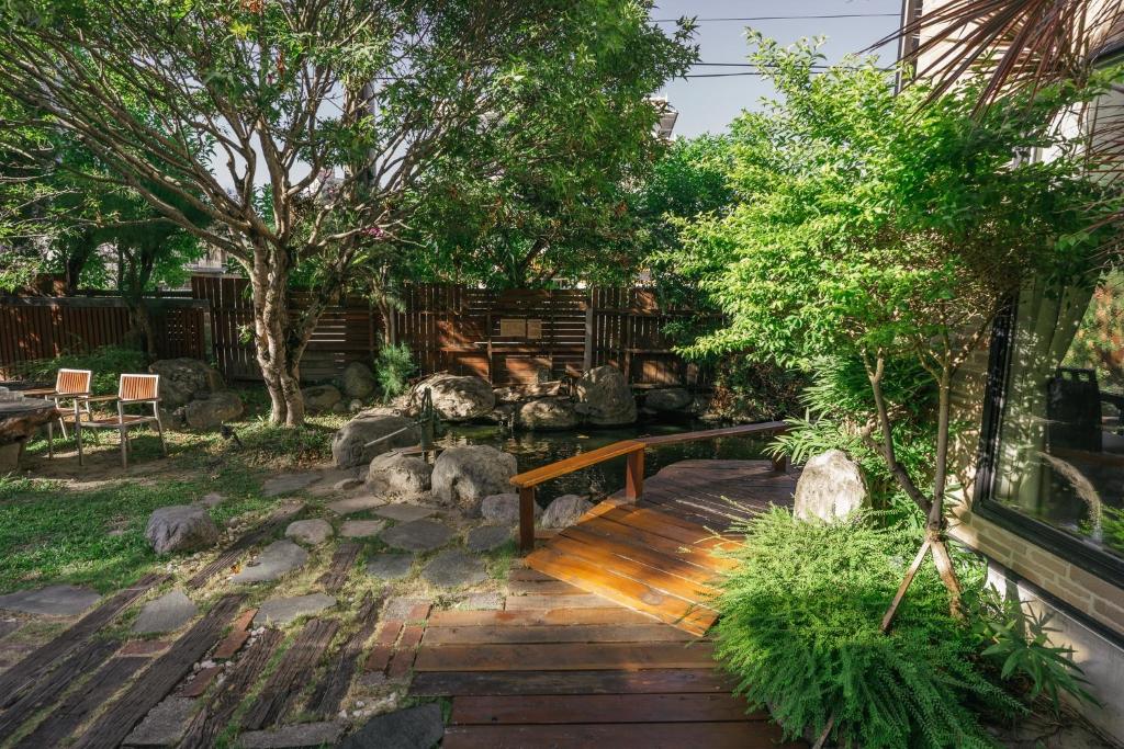 a garden with a wooden bench and trees at 檜木居民宿 - 立案證號 一六三 - 一六八 - 一七零 in Ji&#39;an