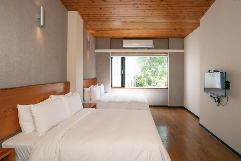 a hotel room with two beds and a window at 檜木居民宿 - 立案證號 一六三 - 一六八 - 一七零 in Ji&#39;an