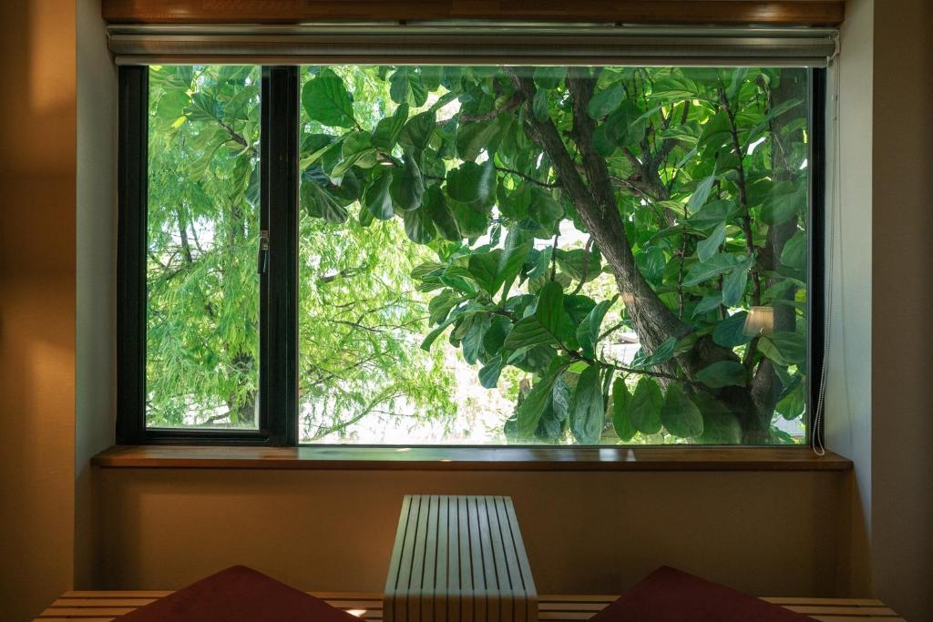 a window in a room with a tree at 檜木居民宿 - 立案證號 一六三 - 一六八 - 一七零 in Ji&#39;an