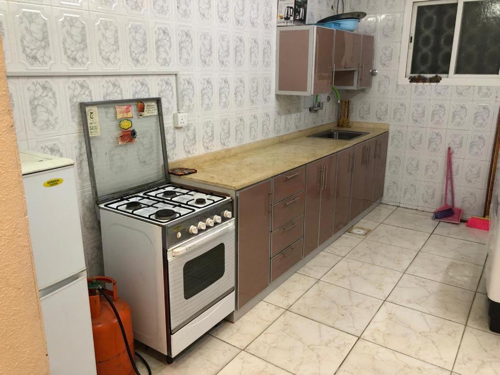 a kitchen with a stove and a refrigerator at بيت المصيف in Taif