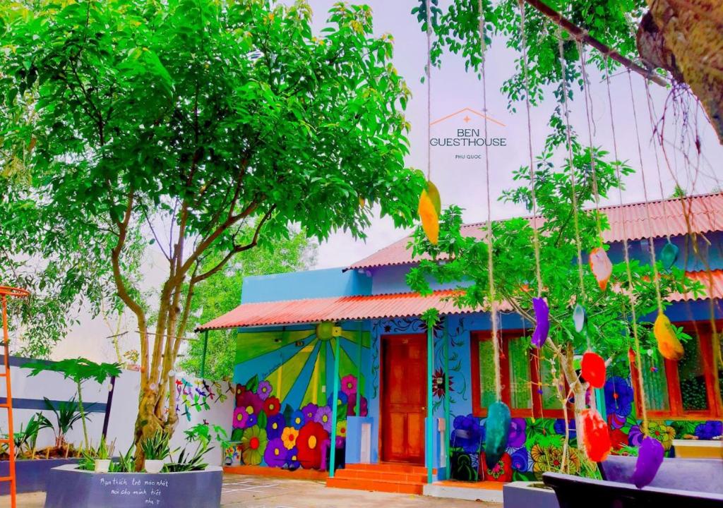 un edificio colorido con un árbol delante en Ben Guesthouse Phu Quoc, en Phu Quoc