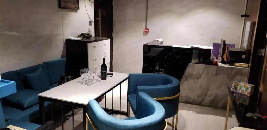香港的住宿－Sleep Cubee Hostel，餐厅设有蓝色的椅子和一张桌子及一瓶葡萄酒