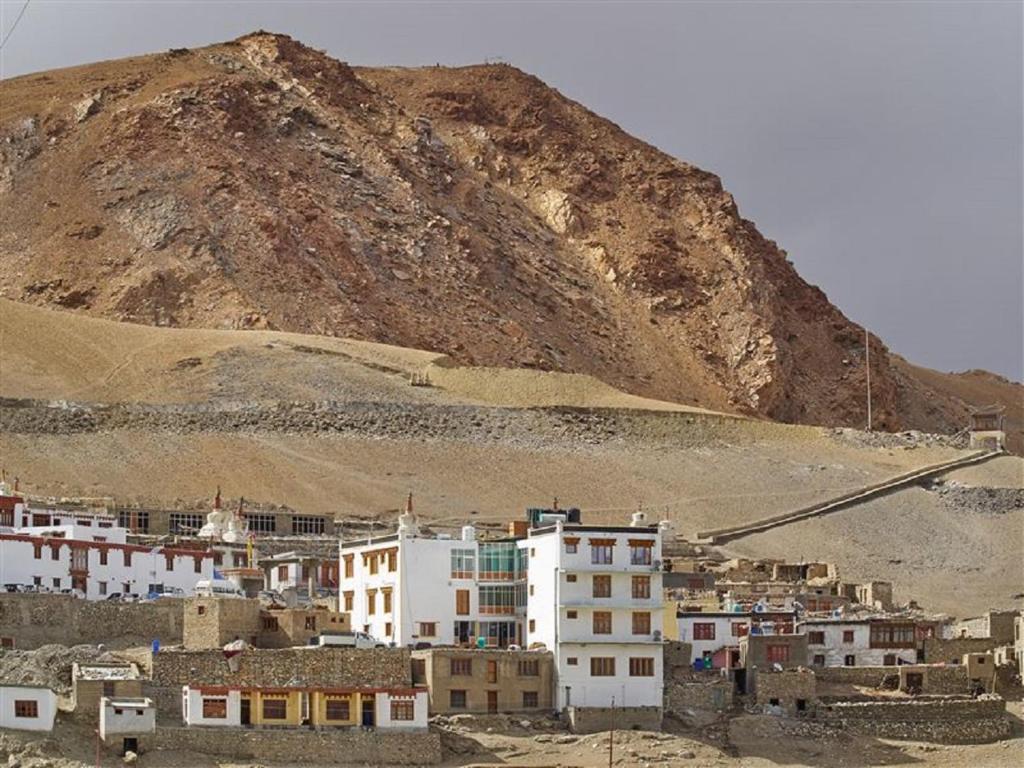 a group of buildings in front of a mountain at Tsomoriri Hotel Lake View in Karzok G&ouml;mpa