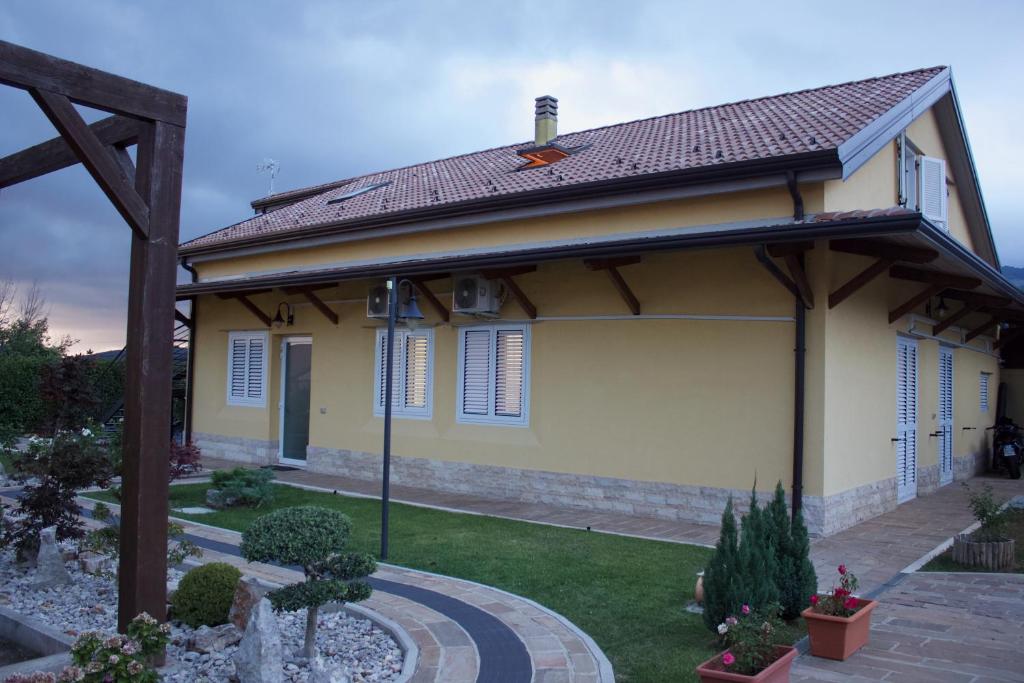 una pequeña casa amarilla con techo en Ostello Villafranca, en Pignola