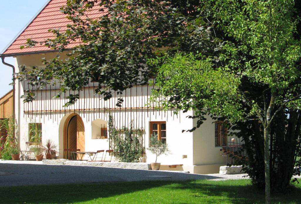 a white house with a red roof at Zuhäusl am Chiemsee Appartements in Breitbrunn am Chiemsee