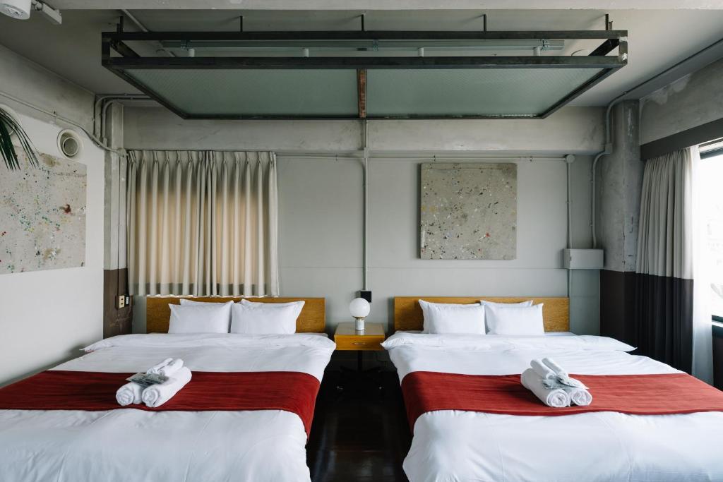 2 Betten in einem Zimmer mit Handtüchern darauf in der Unterkunft HOTEL Inc in Kyoto