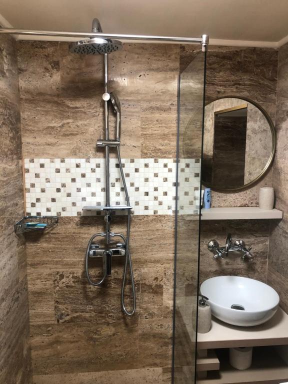 a bathroom with a glass shower with a sink at Family Home in Cheia