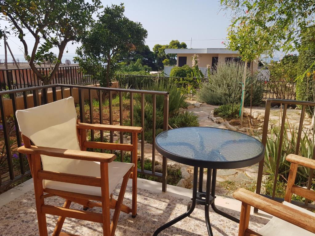 d'une terrasse avec une table, des chaises et une clôture. dans l'établissement Filippos Apartments "Apartment 1", à Céphalonie