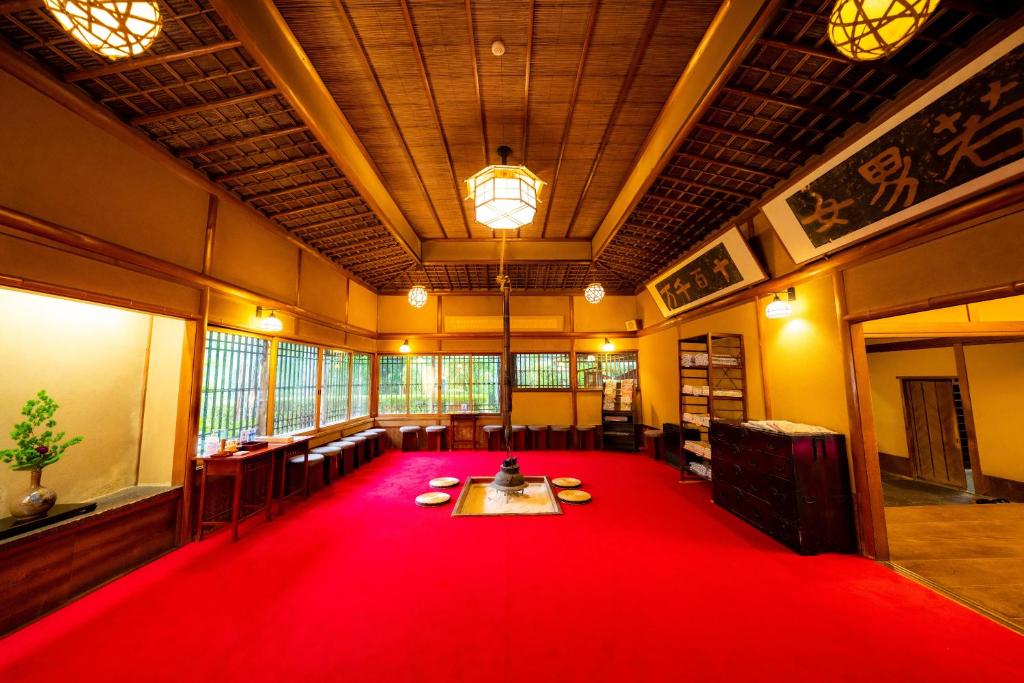 a large room with a red carpet in the middle at Yunoshimakan in Gero