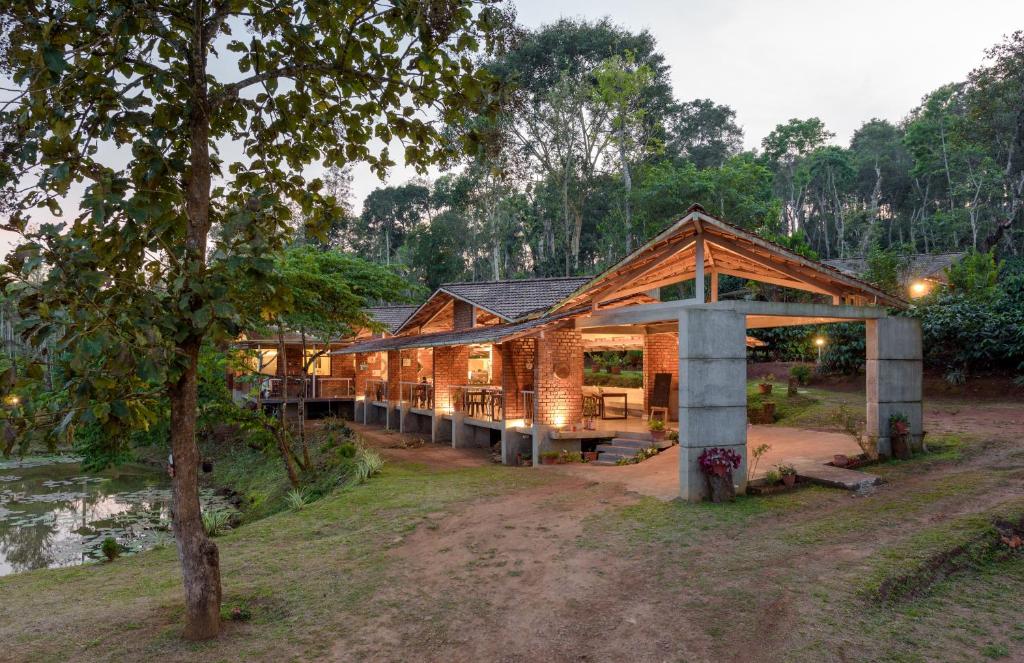 a wooden house in the middle of a forest at Estate Stay - Riverside Coffee in Siddapur