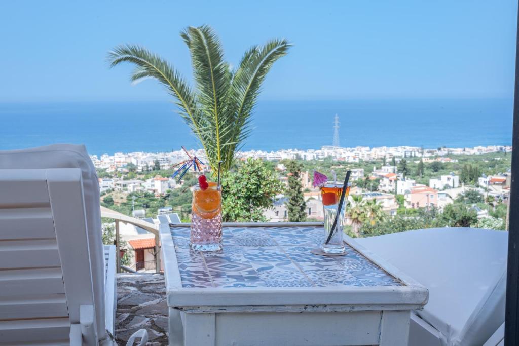 a table with two drinks on top of a balcony at Private Studio Korifi sea view in Hersonissos