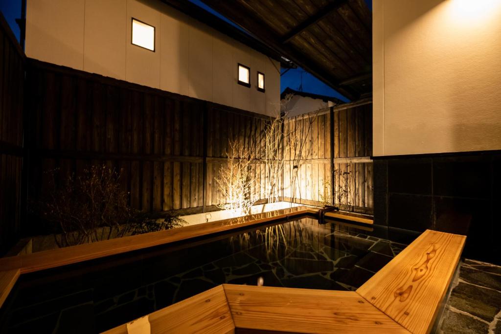 a pool of water in a room with a wooden wall at Kotonone Mai Suzu in Yufu