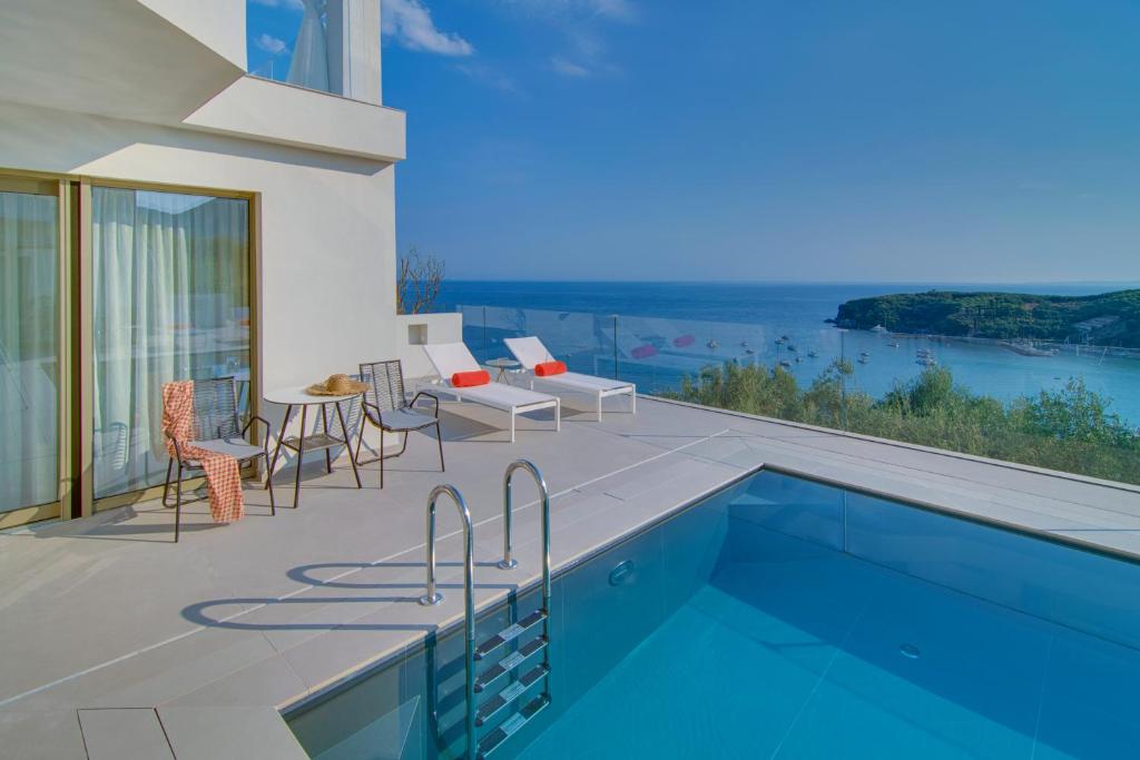 a house with a swimming pool and a patio with a view at LIVINGHOME SUITES in Parga