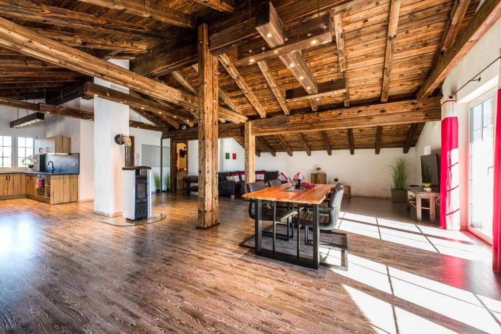 Suite Sinfonie Bergstille في غران: غرفة معيشة مفتوحة بسقوف خشبية وطاولة خشبية