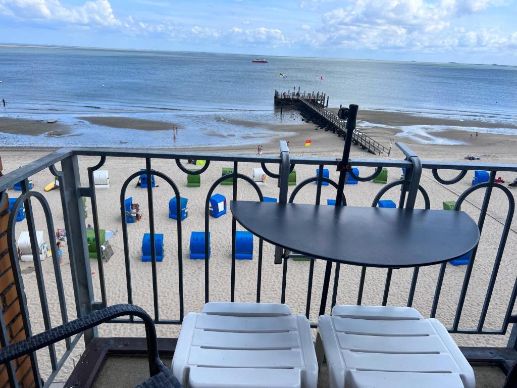 a view of a beach with a table and chairs at Nordland Appartements - Wohnung Alsen in Wyk auf Föhr