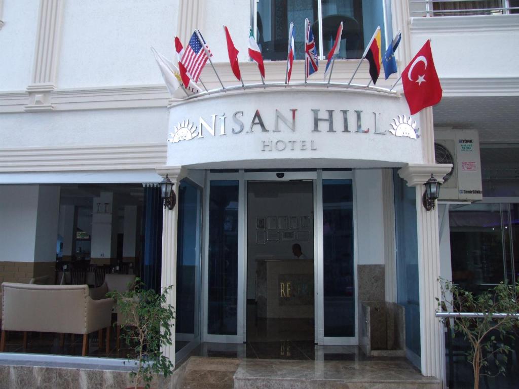 Una señal para un hotel con banderas americanas. en Nisan Hill Hotel, en Kızkalesi