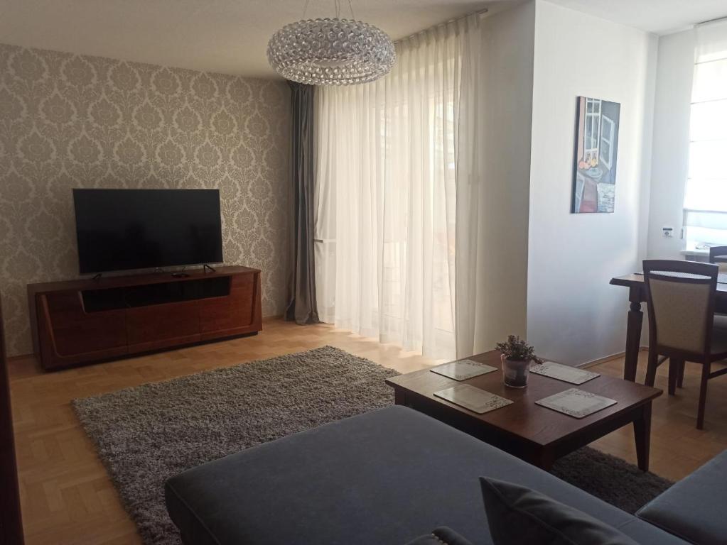 een woonkamer met een bank en een televisie bij Apartament Kościuszki in Kielce