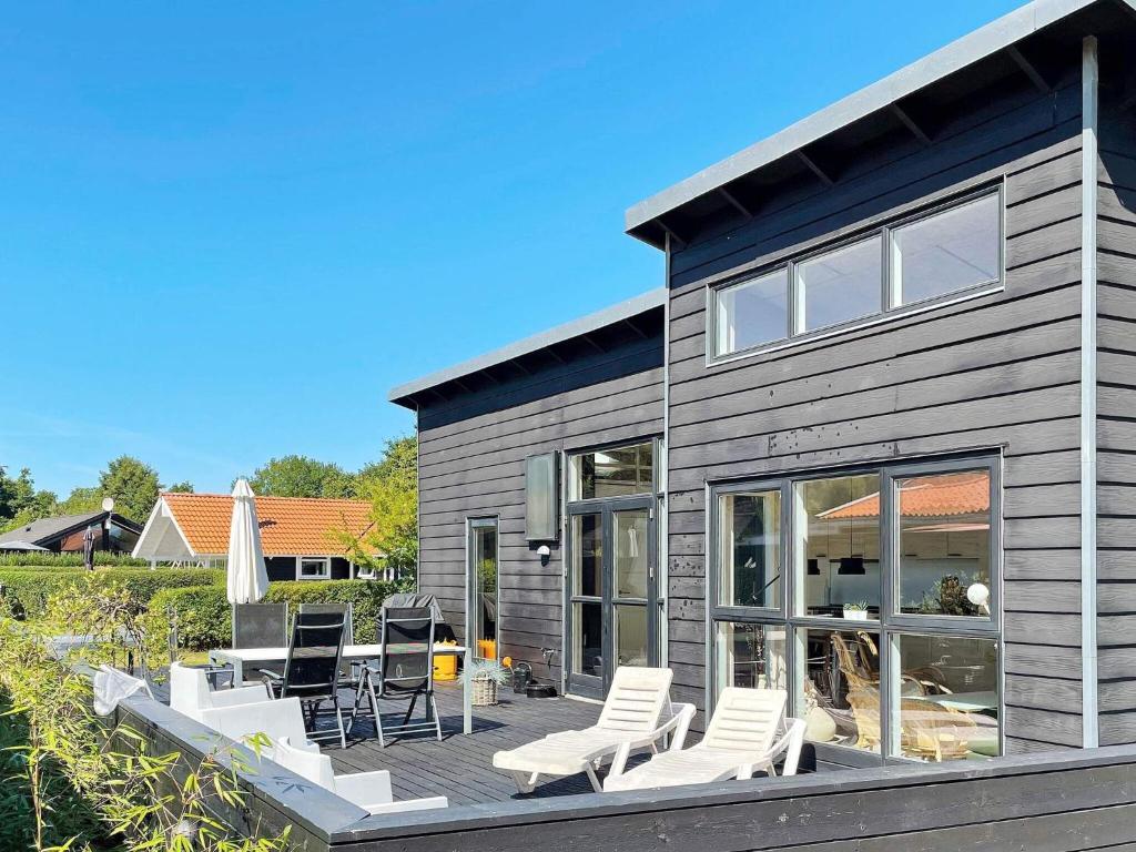 uma casa com um deque com cadeiras e um pátio em 6 person holiday home in Bjert em Sønder Bjert