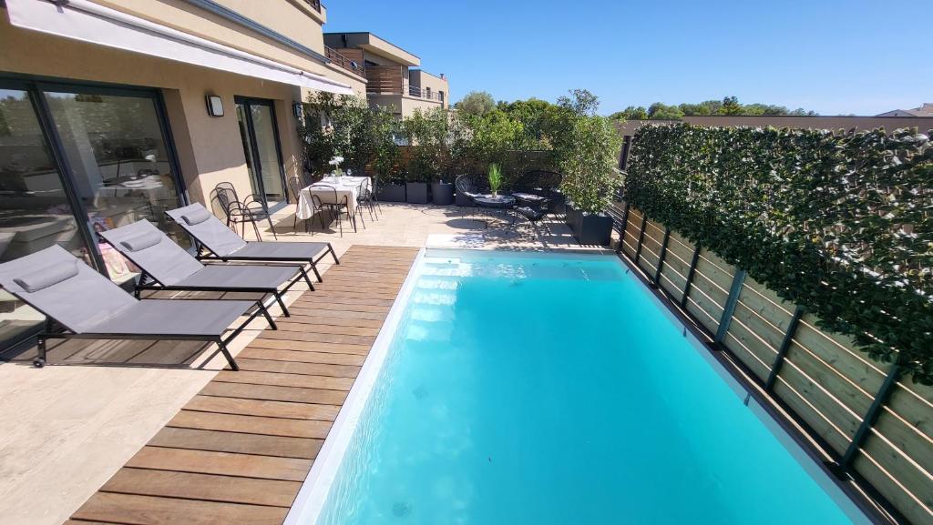 a swimming pool with lounge chairs next to a house at Villa 4 chambres piscine privée à 400m de la plage dans une résidence neuve in Conca