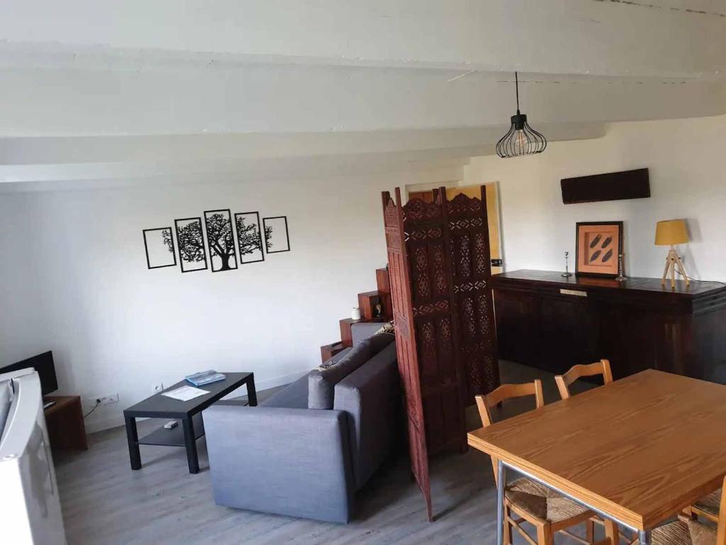 uma sala de estar com um sofá e uma mesa em Logements Bonne Nouvelle em Rostrenen