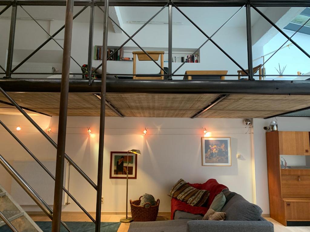 sala de estar con cama elevada y sofá en Le Loft Nautilus by Maison Brasseurs d'Etoiles, en Lieja