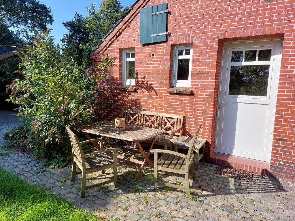a wooden table and chairs in front of a brick building at Fewo Leezdorf in Leezdorf