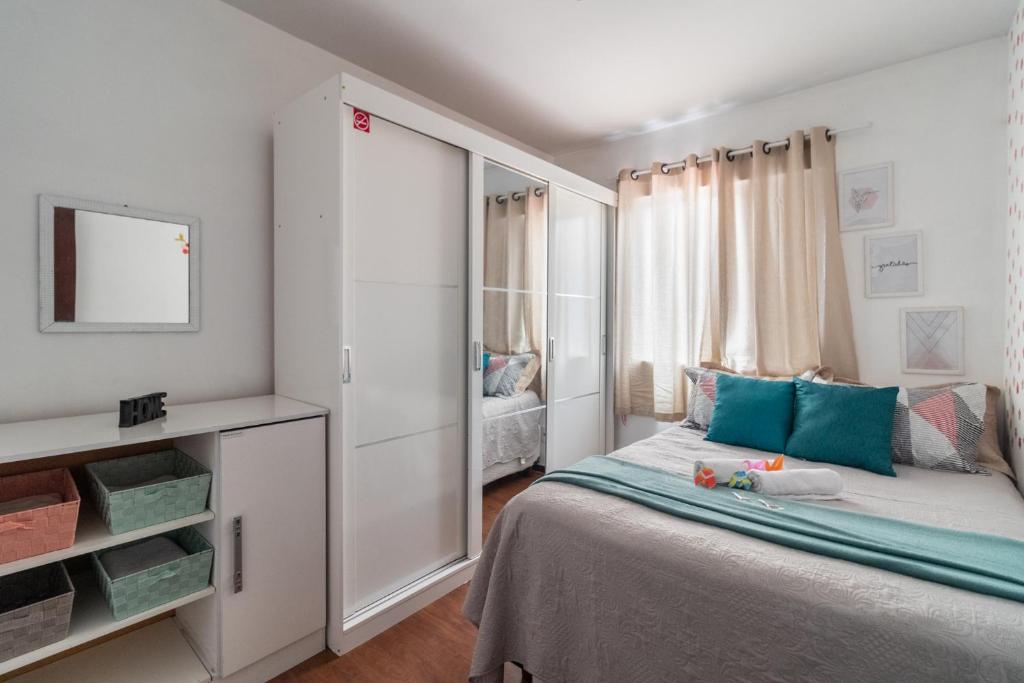 um quarto com uma cama e um grande armário branco em Family Space Curitiba/vaga de garagem Gratis em Curitiba