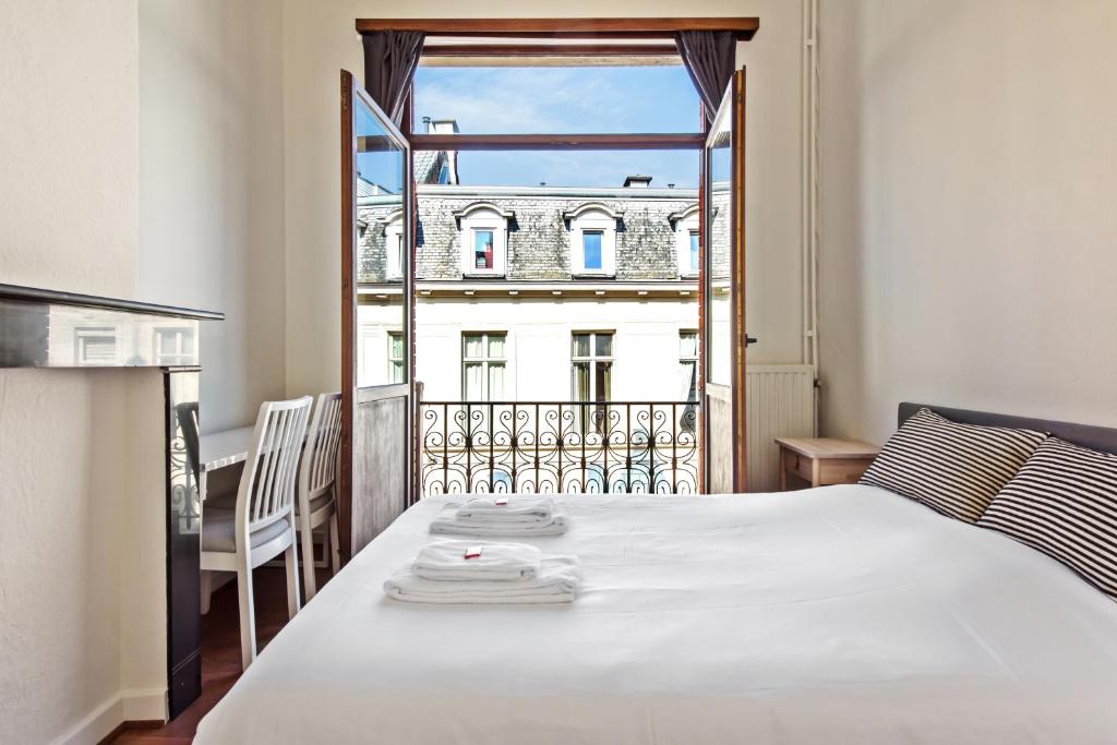 a bedroom with a bed and a view of a building at The Old One Fifteen by Romy&Travis in Ghent