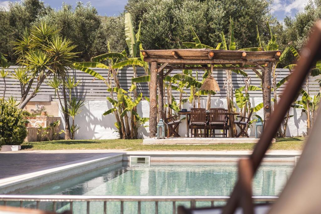 a pool with a gazebo and a table and chairs at Bruma Luxury Residence in Mouzákion