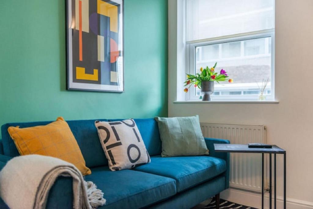 a blue couch in a living room with a window at 2 Bedroom - Tower Bridge - London City by Prime London Stays M-8 in London
