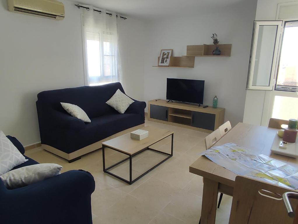 a living room with a blue couch and a table at Els Pilanets in Sant Carles de la Ràpita