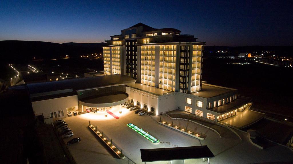 een groot gebouw met 's nachts lichten ervoor bij ALUSSO THERMAL HOTEL SPA in Afyon
