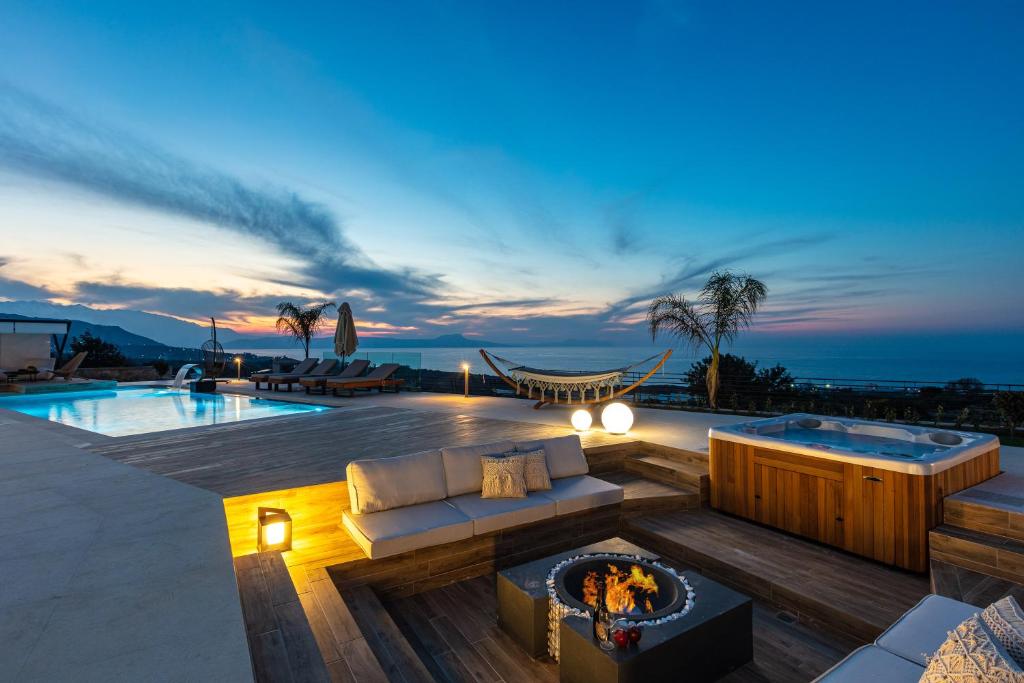 une terrasse avec un foyer extérieur et une piscine dans l'établissement Mageia Exclusive Residence, à Vederoi